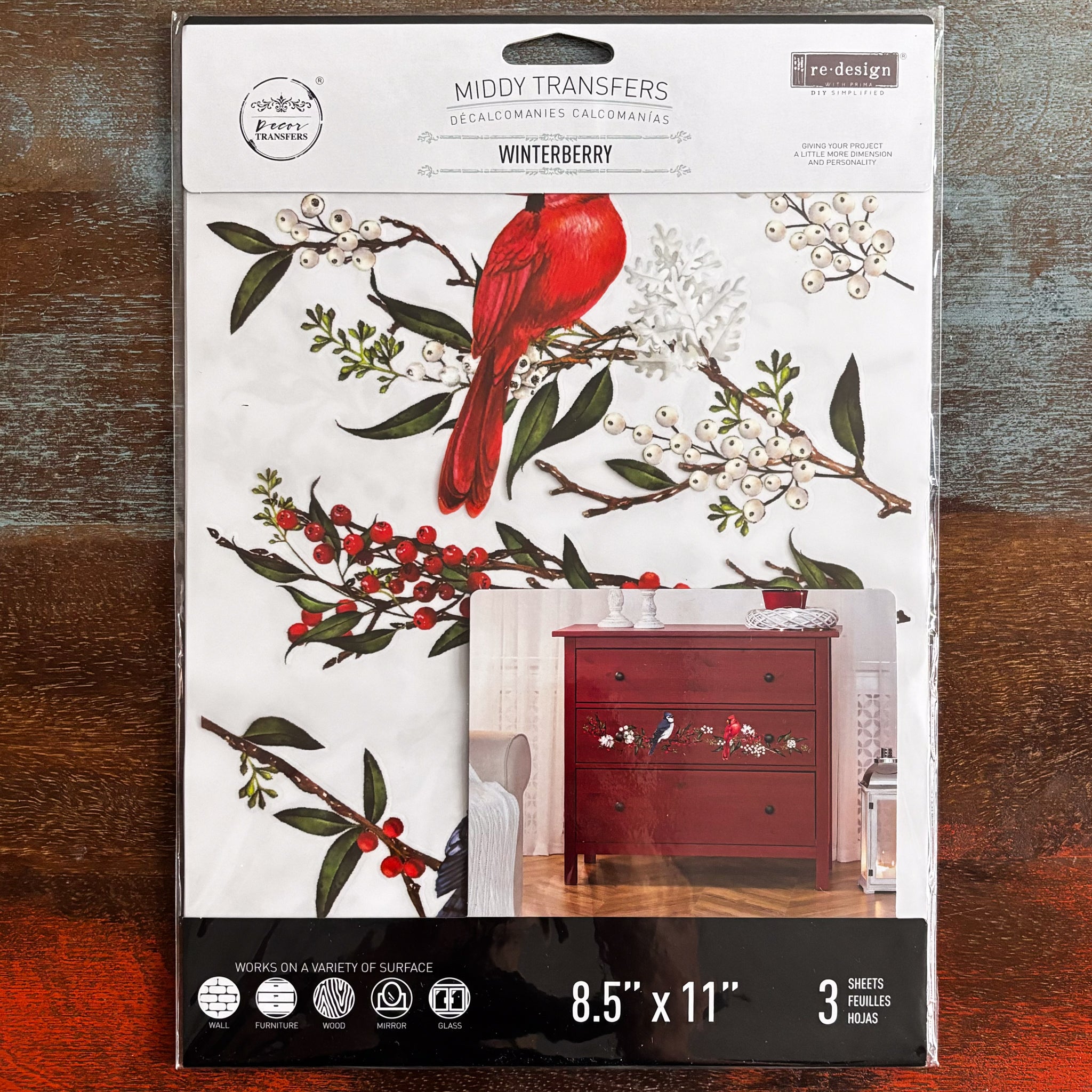 A package of ReDesign with Prima's Winterberry small transfer is against a dark wood background.