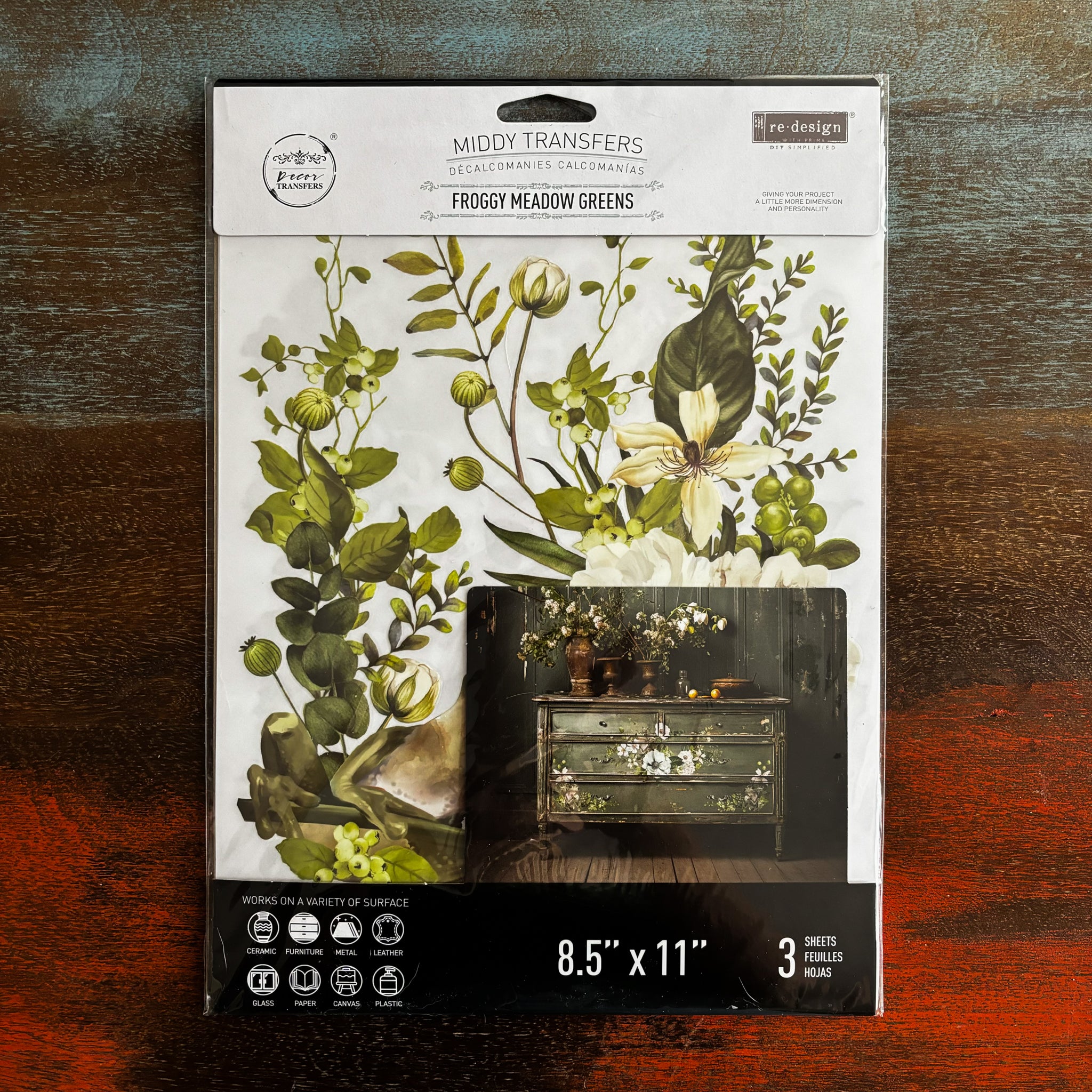 A package of ReDesign with Prima's Froggy Meadow Greens is against a dark wood background.