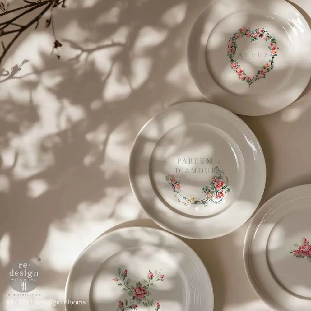 A close-up of 4 white plates feature ReDesign with Prima's Nostalgic Blooms H2O Water Slide Transfers on them.