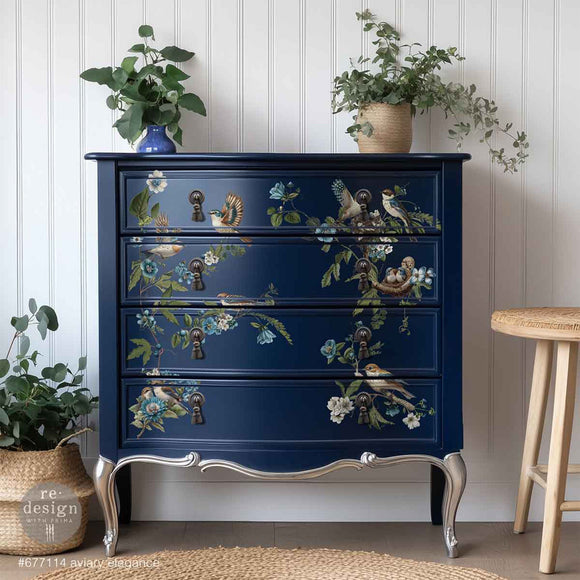 A vintage 4-drawer chest dresser is painted navy blue and features ReDesign with Prima's Aviary Elegance rub-on furniture transfer on the drawers.
