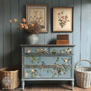 A 4-drawer dresser is painted a muted light blue and features ReDesign with Prima's Aviary Elegance rub-on furniture transfer on the front.
