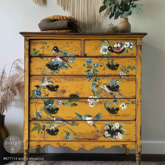 A vintage 6-drawer chest dresser is painted amber yellow and features ReDesign with Prima's Aviary Elegance rub-on furniture transfer on the front.