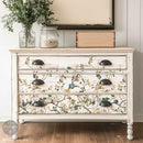 A vintage 3-drawer dresser is painted soft white and features ReDesign with Prima's Blue Vine rub-on furniture transfer on the drawers.