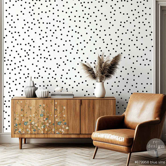 A natural wood mid-century modern TV console features ReDesign with Prima's Blue Vine rub-on furniture transfer on the left front.