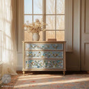 A 3-drawer dresser is painted light beige with pale blue drawer fronts and features ReDesign with Prima's Blue Vine rub-on transfer over the blue paint.