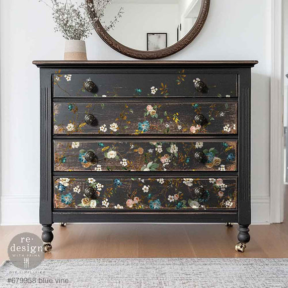 A vintage 4-drawer chest dresser is painted black and features ReDesign with Prima's Blue Vine rub-on transfer on the drawers.