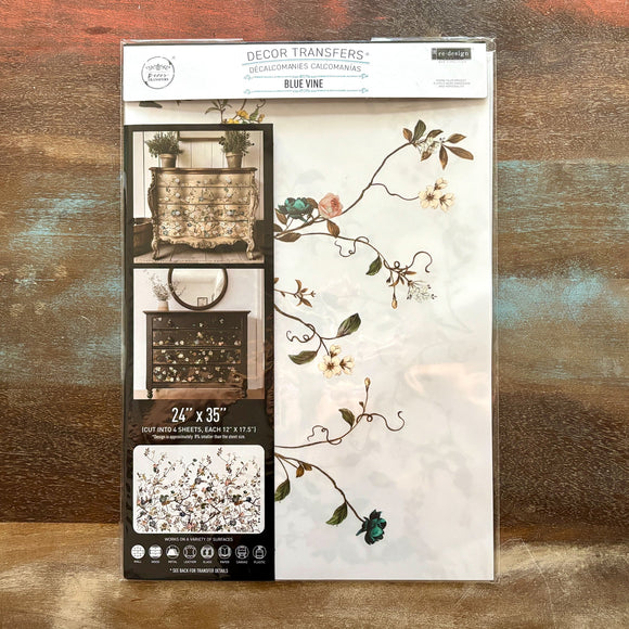 A package of ReDesign with Prima's Blue Vine rub-on furniture transfer is against a wood background.