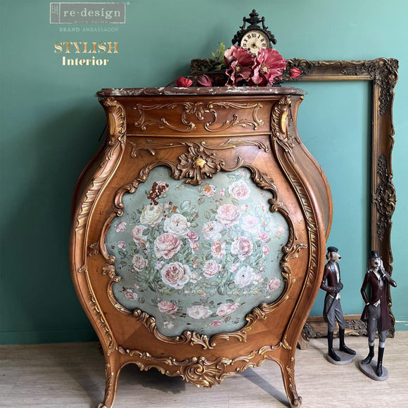 A vintage Bombay style side table refurbished by Stylish Interior has natural wood and features ReDesign with Prima's Blush Blossoms middy rub-on transfer in a door inlay over light teal paint.