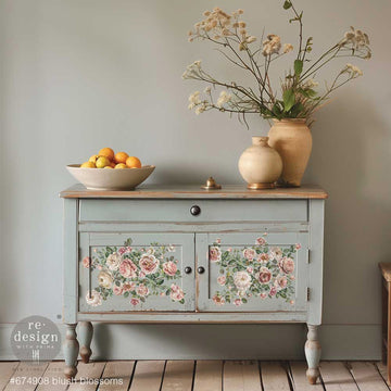A small buffet hutch is painted grey and features ReDesign with Prima's Blush Blossoms small rub-on transfers on its 2 doors.
