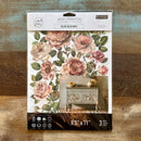 A package of ReDesign with Prima's Blush Blossoms small rub-on transfers is against a wood background.