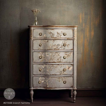 A vintage 5-drawer chest dresser is painted light gray and featured ReDesign with Prima's Branch Harmony rub-on furniture transfer on the drawers.