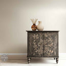 A small buffet cabinet painted with a black-wash style design features ReDesign with Prima's Branch Harmony rub-on furniture transfer on its 2 doors.