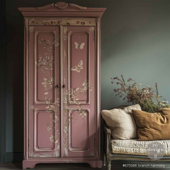 A vintage armoire is painted blush pink and features ReDesign with Prima's Branch Harmony rub-on furniture transfer on its doors.