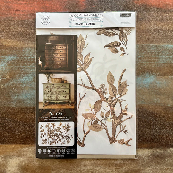 A package of ReDesign with Prima's Branch Harmony rub-on furniture transfer is against a wood background.