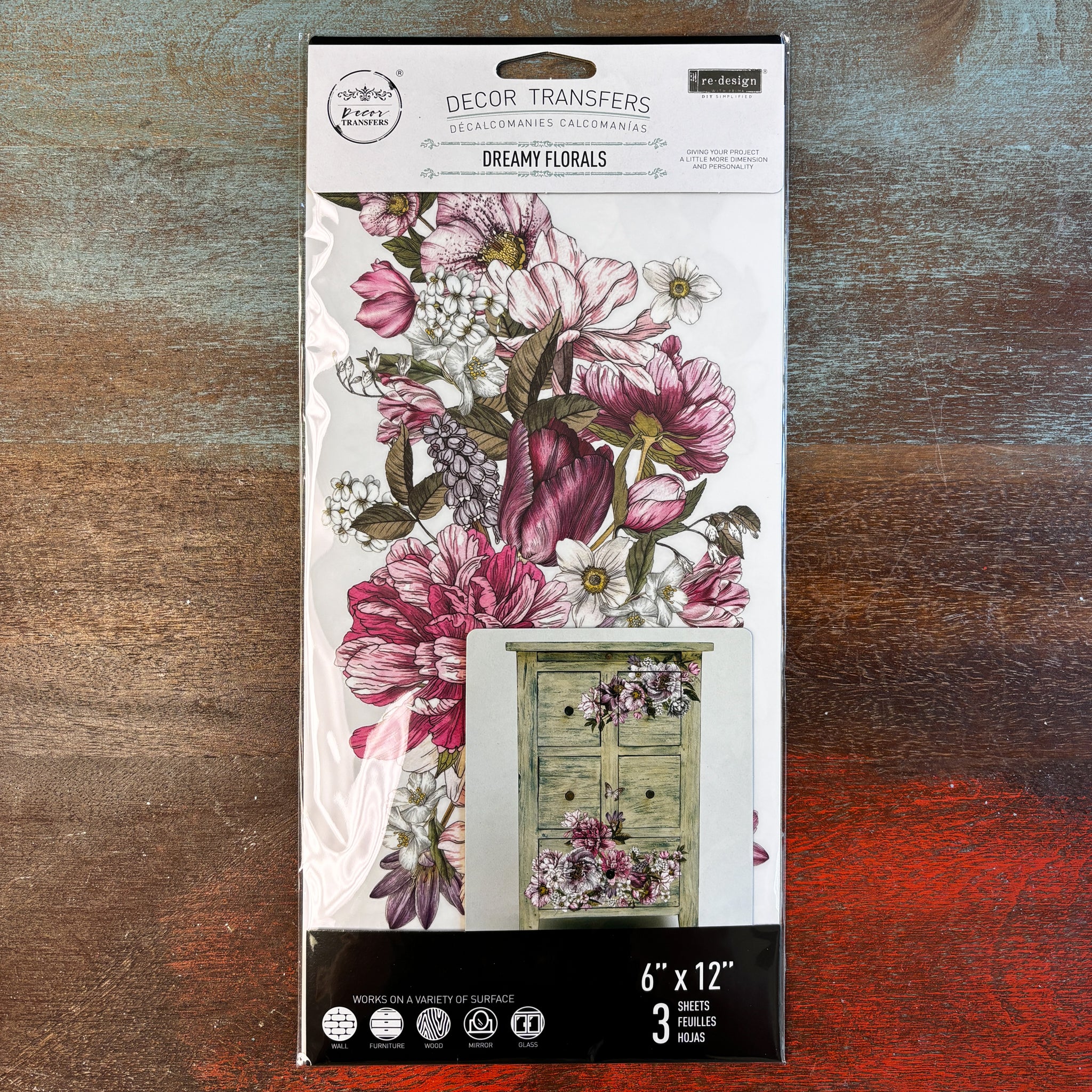 A package of ReDesign with Prima's Dreamy Florals small transfer is against a dark wood background.