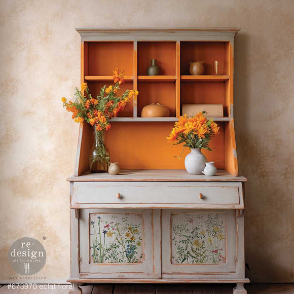 A vintage hutch is painted light grey with orange and features ReDesign with Prima's Eclat Floral small rub-on transfers on its 2 bottom cabinet doors.