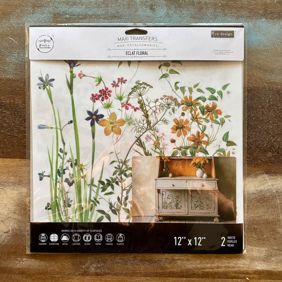 A package of ReDesign with Prima's Eclat Floral 12"x12" rub on transfers are against a wood background.