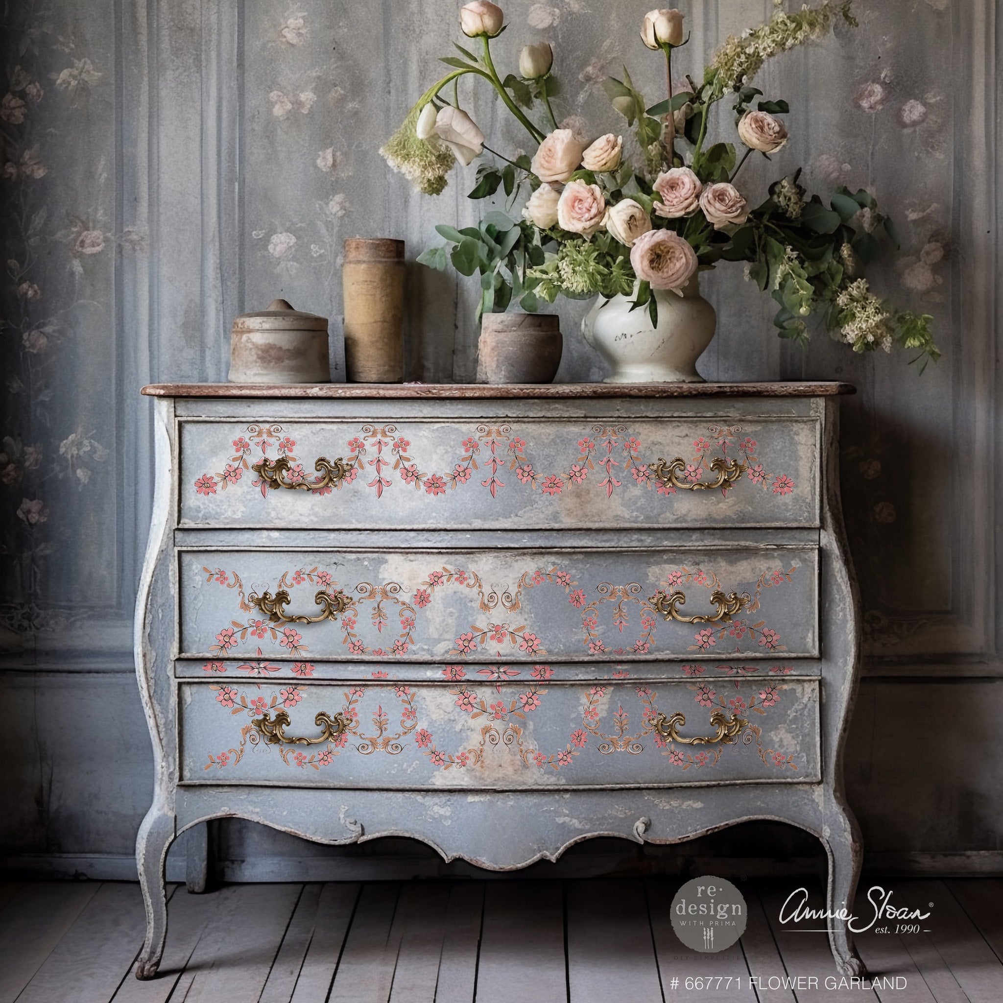 A vintage 3-drawer dresser refurbished by Annie Sloan is painted light gray and features ReDesign with Prima's Annie Sloan Flower Garland rub-on transfer on the drawers.