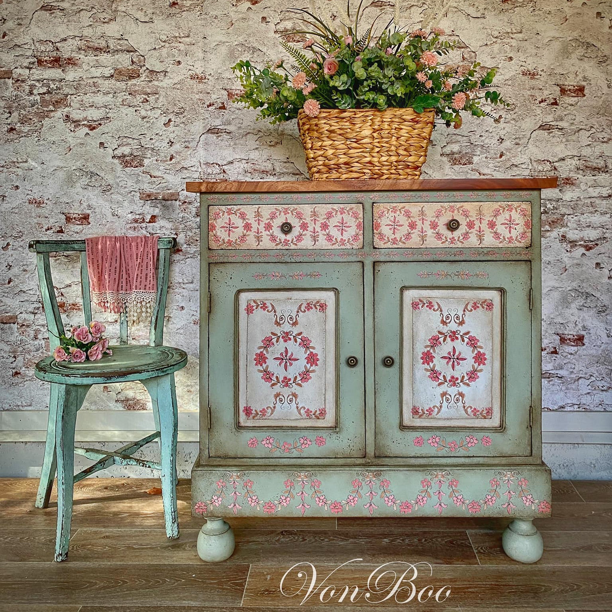 A vintage storage console refurbished by Von Boo is painted pale green and features ReDesign with Prima's Annie Sloan Flower Garland rub-on transfer on the front.