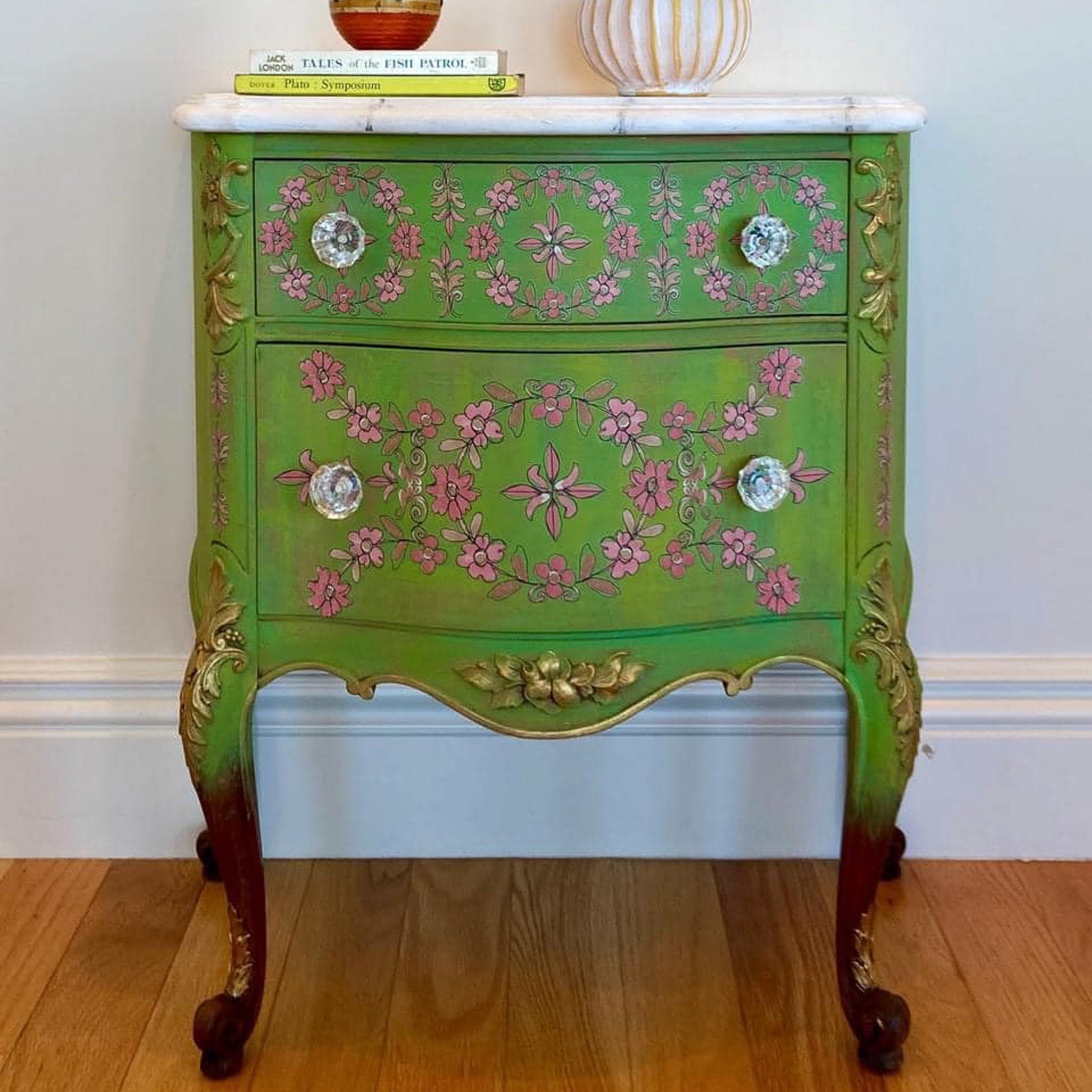 A vintage 2-drawer nightstand is painted green and features ReDesign with Prima's Annie Sloan Flower Garland rub-on transfer on the drawers.