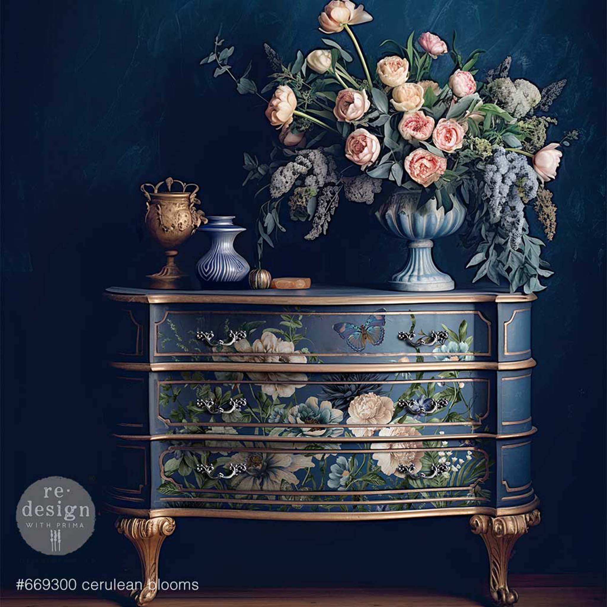 A vintage 3-drawer dresser is painted blue with gold accents and features ReDesign with Prima's Cerulean Blooms rub-on transfer on the drawers.