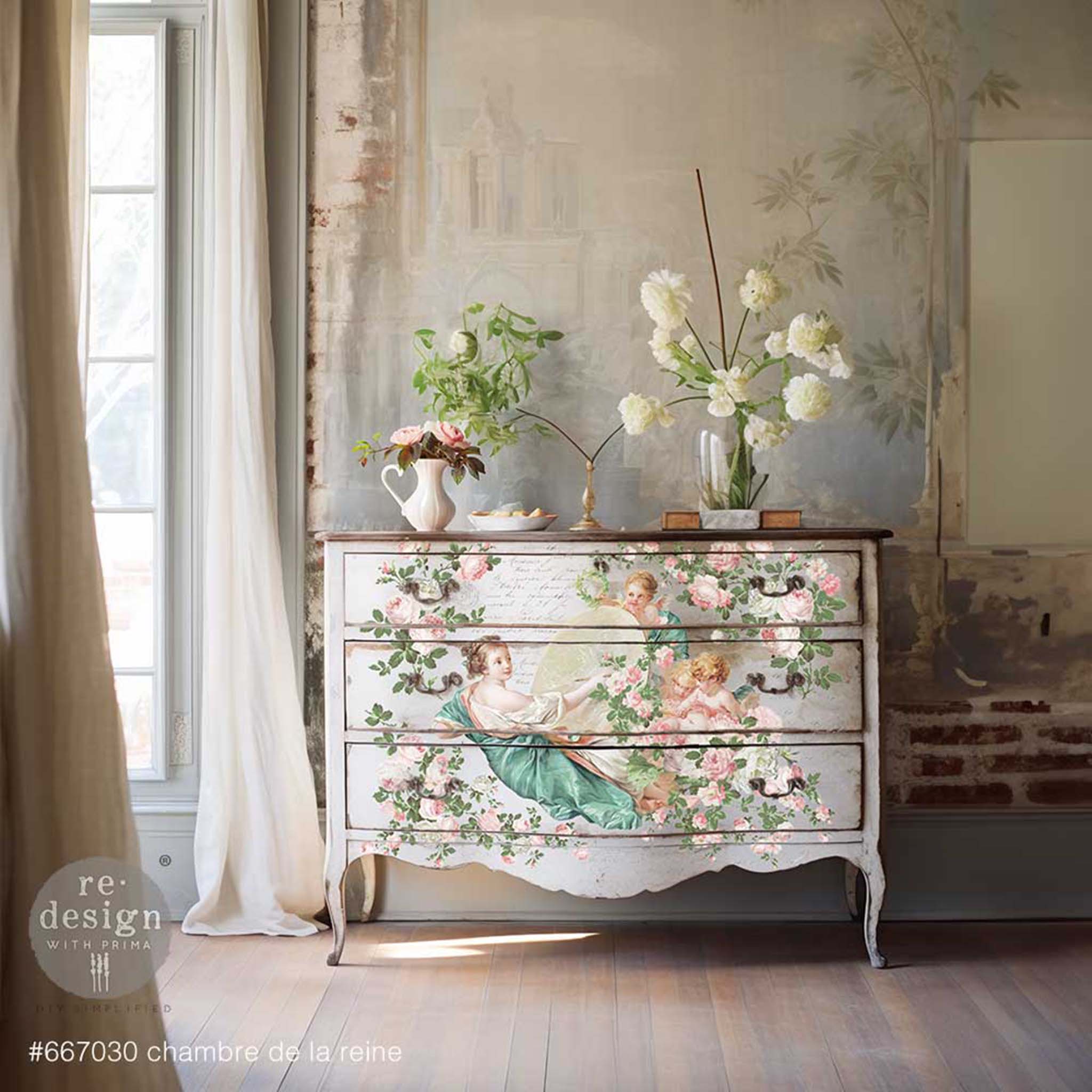 A vintage 3-drawer dresser is painted white and features ReDesign with Prima's Chambre De La Reine rub-on transfer on the drawers.