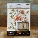 A package of ReDesign with Prima's Gentle Symphony small rub-on transfers is against a wood background.