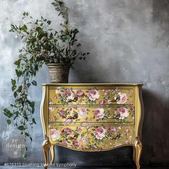 A vintage 3-drawer dresser is painted golden yellow and features ReDesign with Prima's Kacha Blushing Blooms Symphony Transfer for furniture on the drawers.
