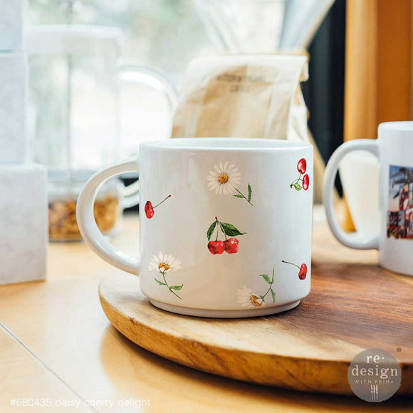 White ceramic mug decorated with daisy and cherry Luxe Transfer decals on a kitchen counter