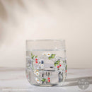 Clear glass tumbler decorated with daisy and cherry Luxe Transfer design, shown on drinkware over ice