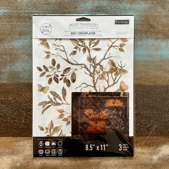 A package of ReDesign with Prima's Quiet Contemplation middy rub-on transfers is against a wood background.