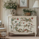 Decorative chest of drawers with floral and bird design in a room setting.