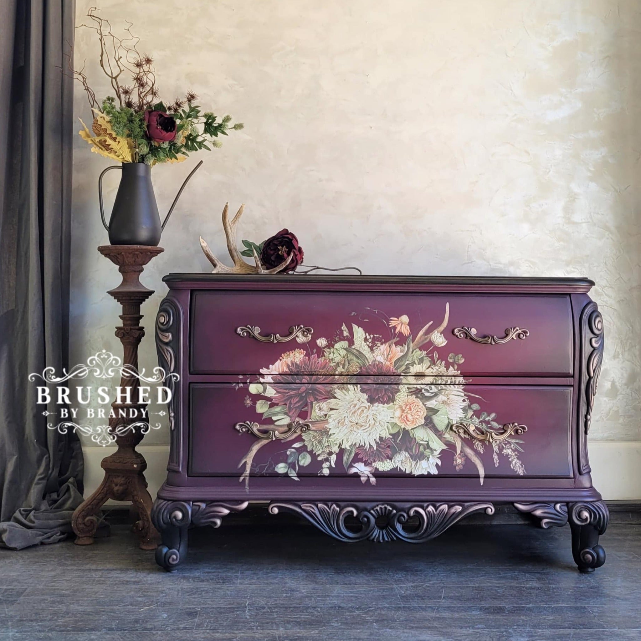 A 2-drawer dresser refurbished by Brushed by Brandy is painted purple and features ReDesign with Prima's Rustic Charm furniture transfer on the drawers.