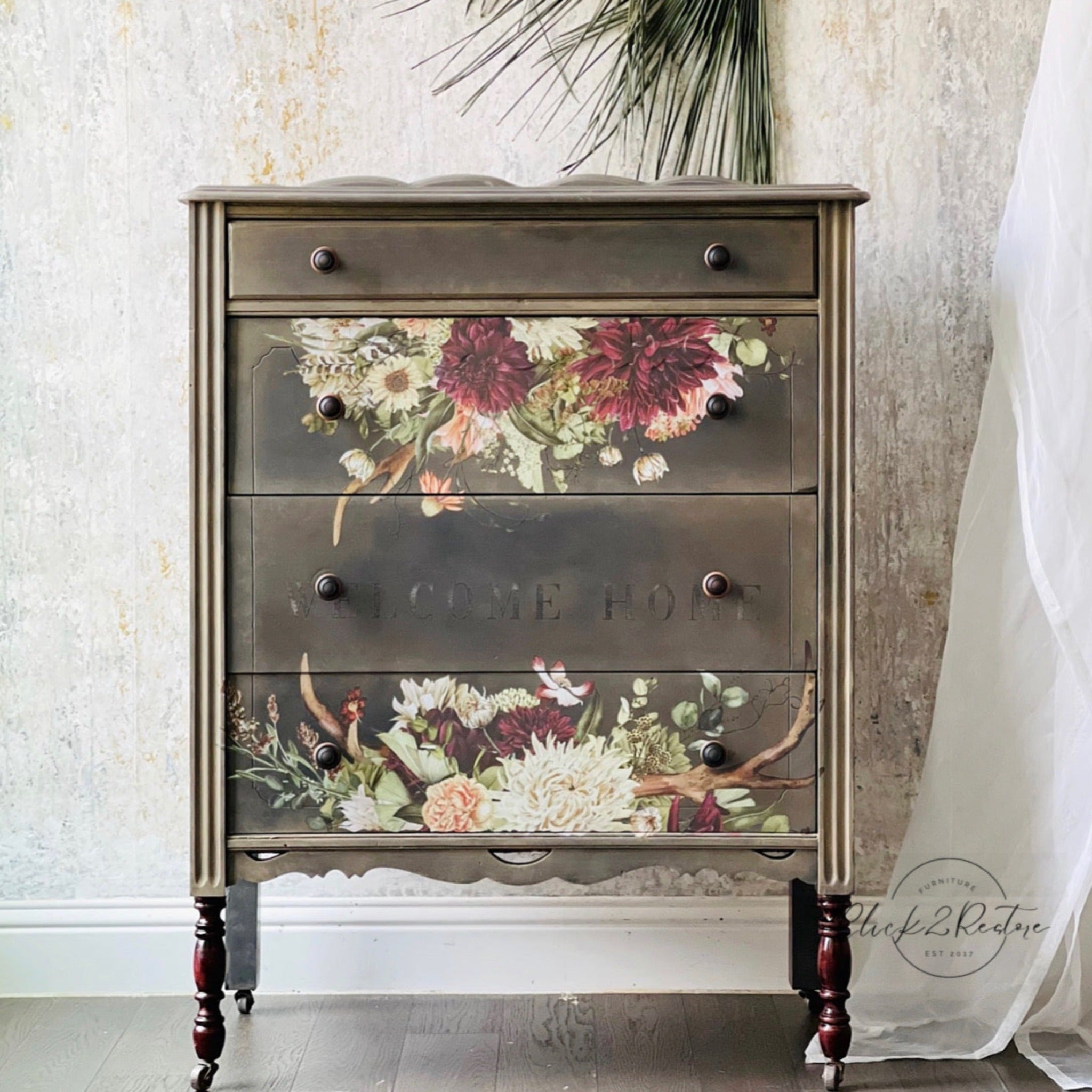 A vintage 4-drawer dresser is painted light brown and features ReDesign with Prima's Rustic Charm furniture transfer on its 2nd and 4th drawer.