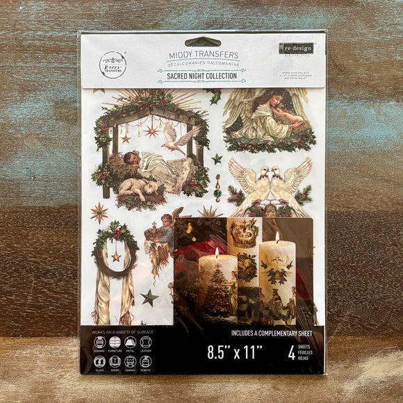 A package of ReDesign with Prima's Sacred Night Collection middy rub-on transfers are against a wood background.