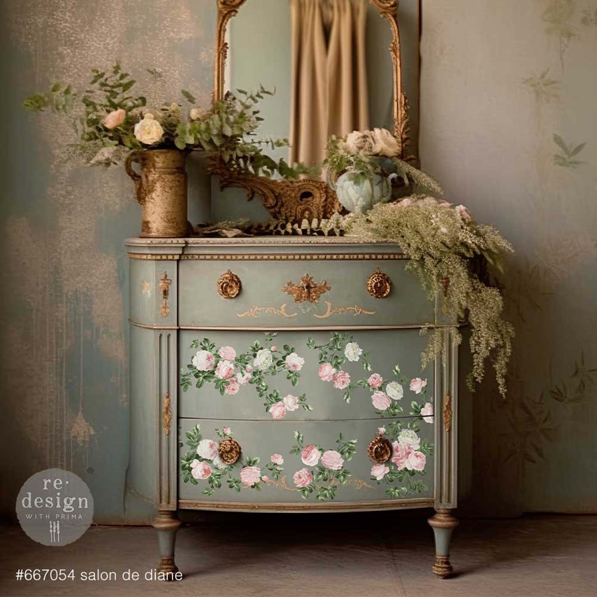 A vintage 3-drawer nightstand is painted grey with bronze accents and features ReDesign with Prima's Salon De Diane 12"x12" rub-on transfer on its 2 bottom drawers.