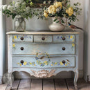  A vintage 5-drawer dresser is painted pale blue and features ReDesign with Prima's Sunlit Aviary small rub-on transfers on the drawers.