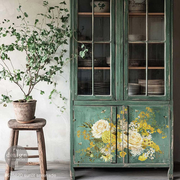 A hutch cabinet painted a muted green features ReDesign with Prima's Sunlit Serenade Transfer for large furniture on the bottom 2 doors.