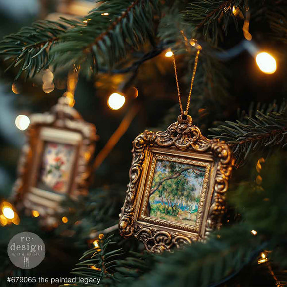Decorative Christmas ornament with gold frame and painting inside, hanging on a tree with lights.