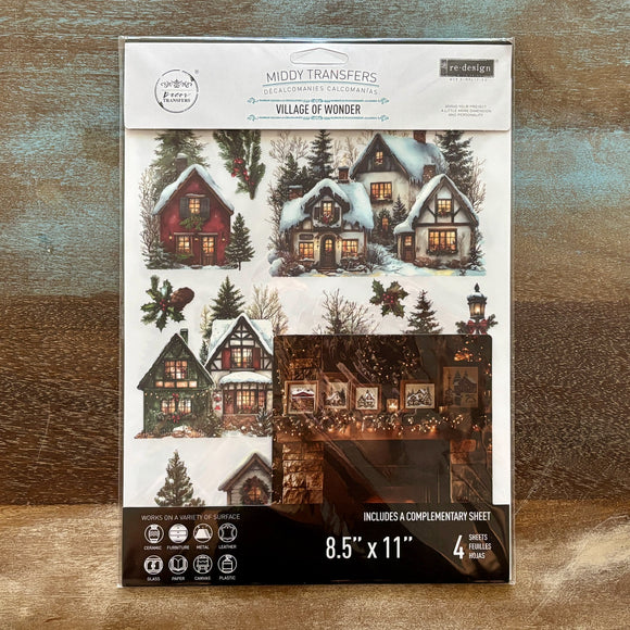 A package of ReDesign with Prima's Village of Wonder middy rub-on transfers is against a wood background.