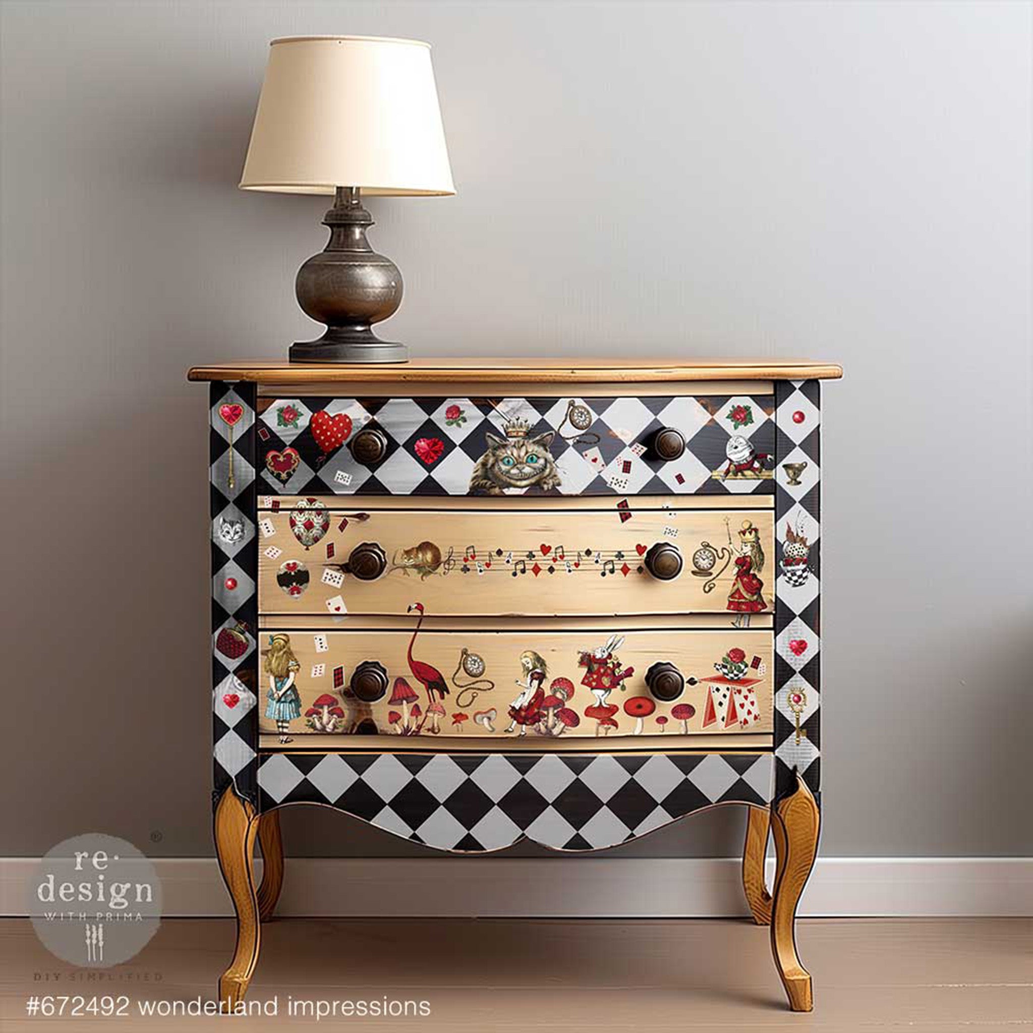 A vintage 3-drawer nightstand has 2 natural wood drawers and the rest is painted with black and light grey harlequin diamonds and features ReDesign with Prima's Wonderland Impressions middy transfers on it.