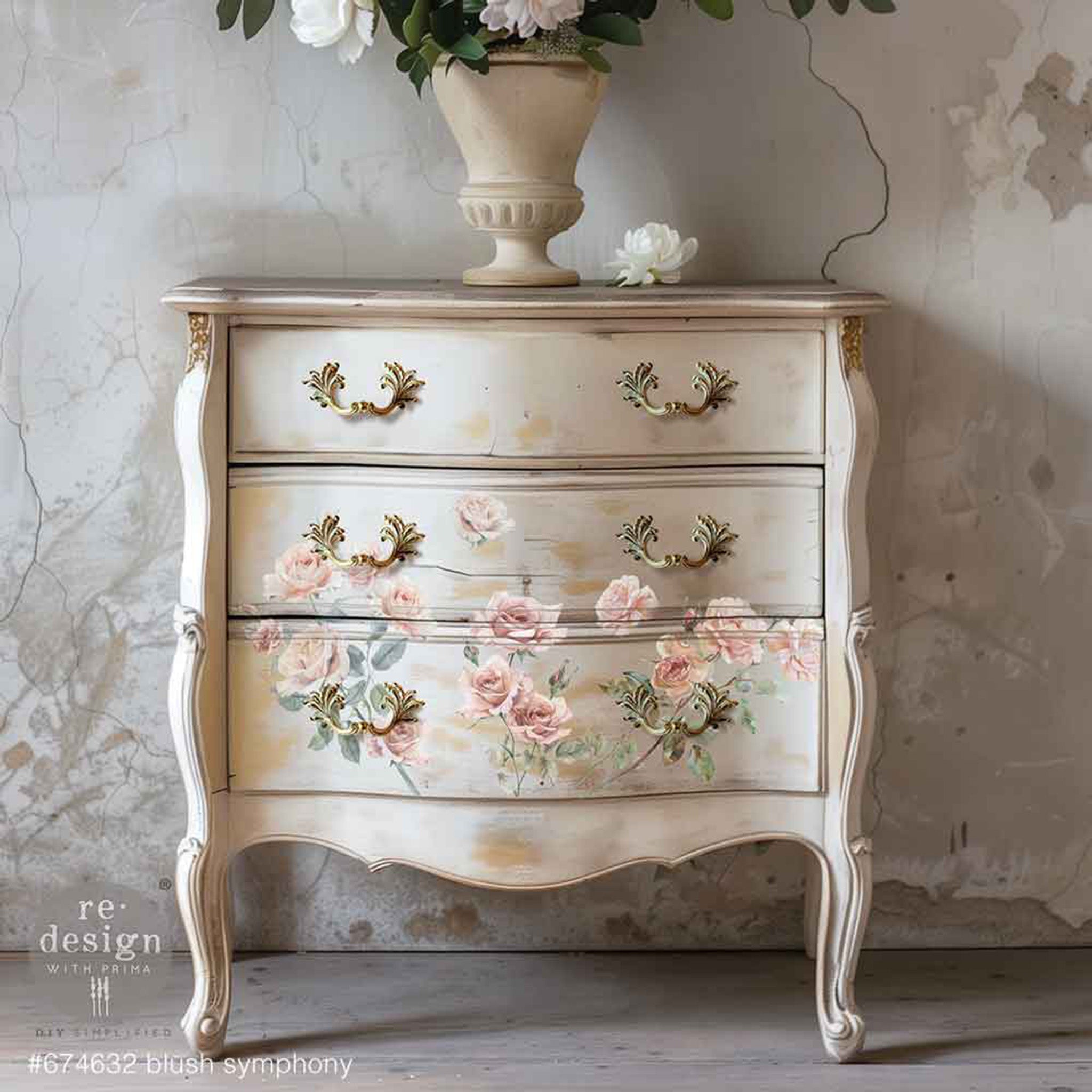 A vintage 3-drawer small dresser is painted light beige and features ReDesign with Prima's Blush Symphony small rub-on transfers on the bottom 2 drawers.