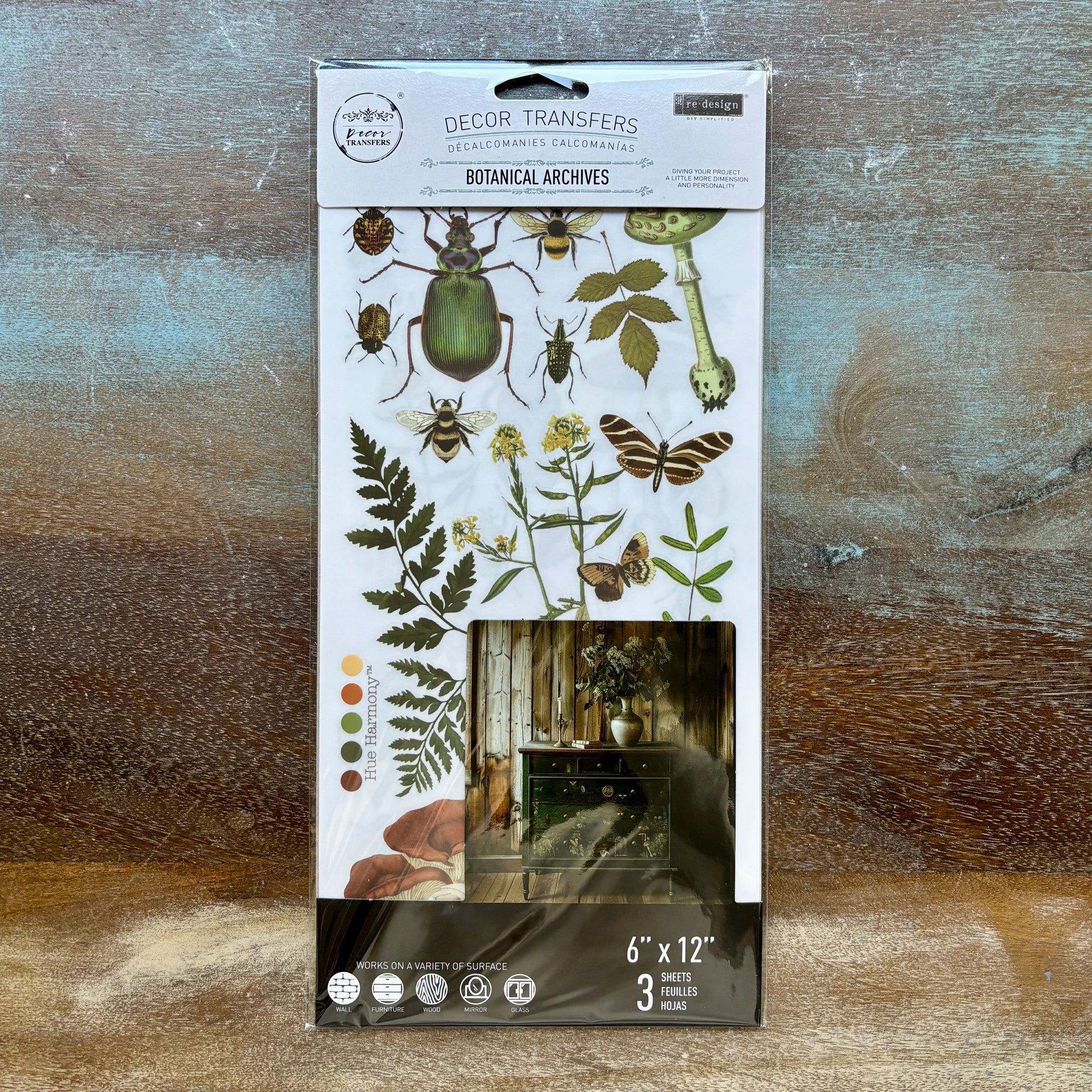 A package of ReDesign with Prima's Botanical Archives small rub-on transfers is against a wood background.