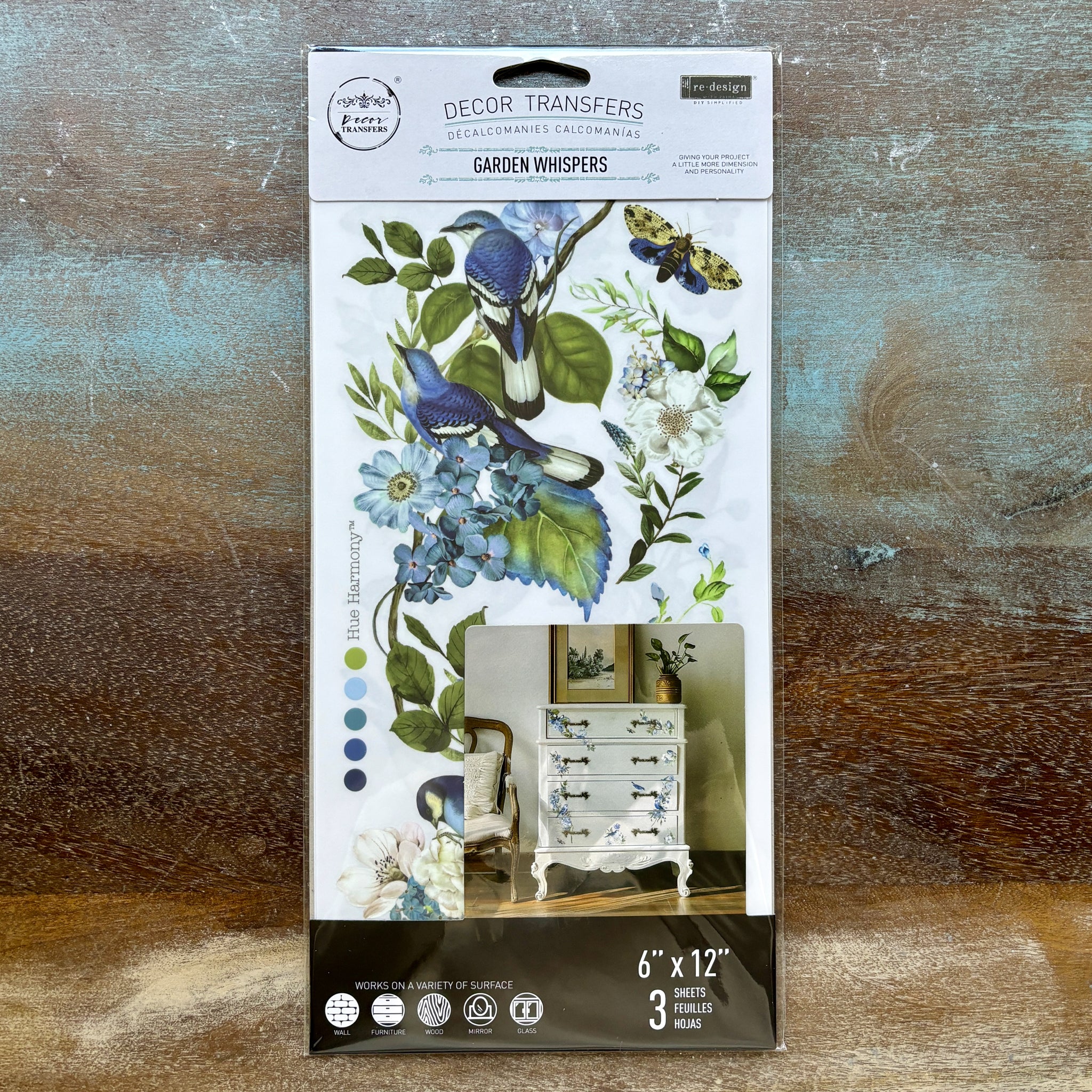 A package of ReDesign with Prima's Garden Whispers small rub-on transfers is against a wood background.