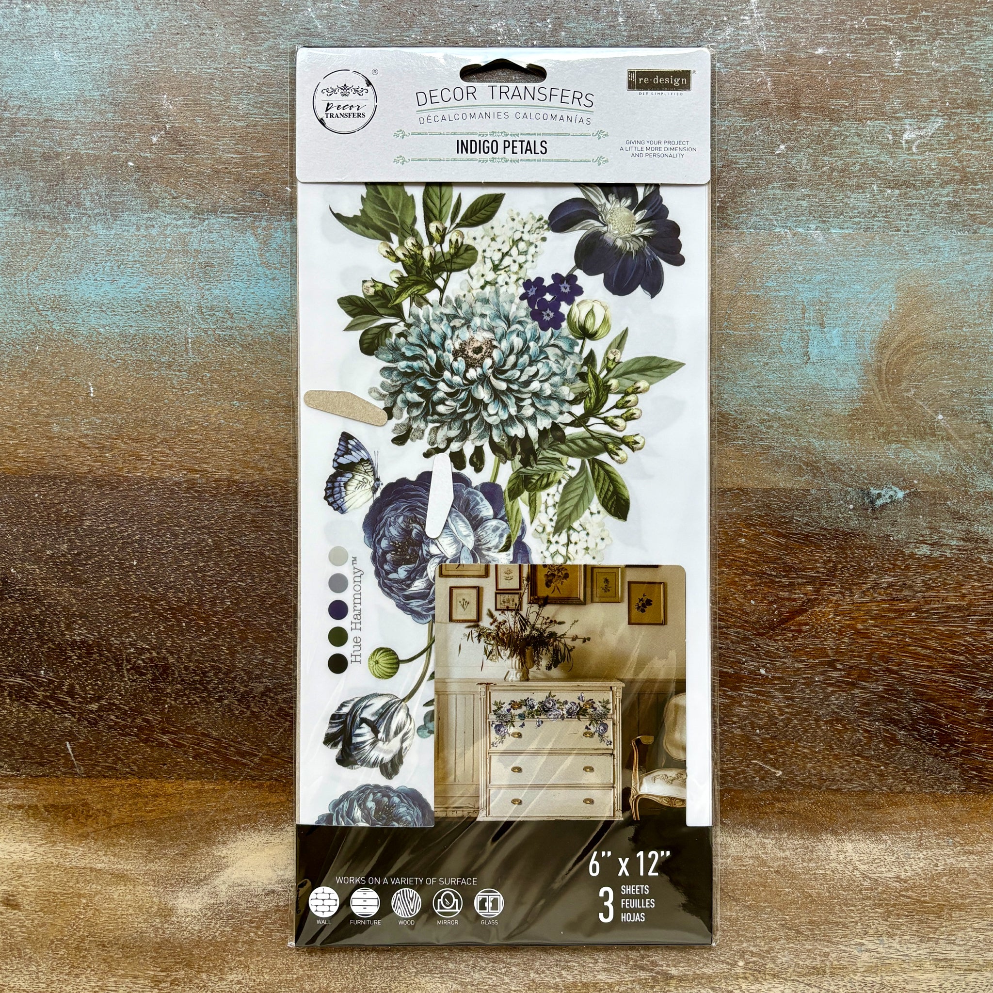 A package of ReDesign with Prima's Indigo Petals small rub-on transfers is against a wood background.