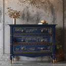 A vintage style 3-drawer dresser is painted navy blue with gold accents and features ReDesign with Prima's Kacha Shimmer Script Gold Foil small transfer on the drawers.