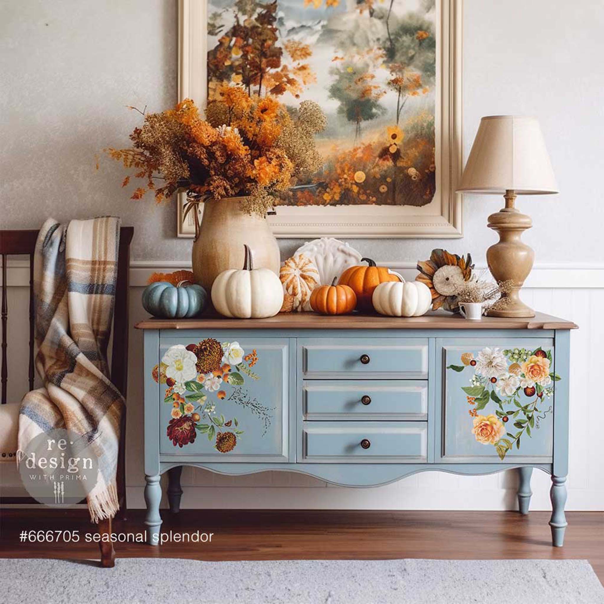 A vintage light blue console table with a natural wood top features ReDesign with Prima's Seasonal Splendor small transfer on its 2 doors.