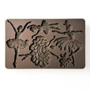 A brown silicone mold of 3 adult ballerinas, a child ballerina, and a bouquet of flowers is against a white background.