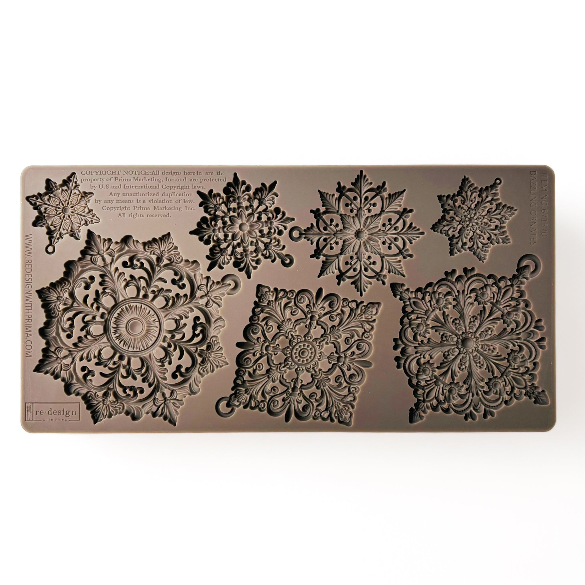 A brown silicone mold of 3 large and 4 smaller ornately decorated snowflakes is against a white background.