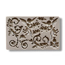 A silicone mold featuring cherubs, intricate scrolling designs, and a vase with roses around it is against a white background.